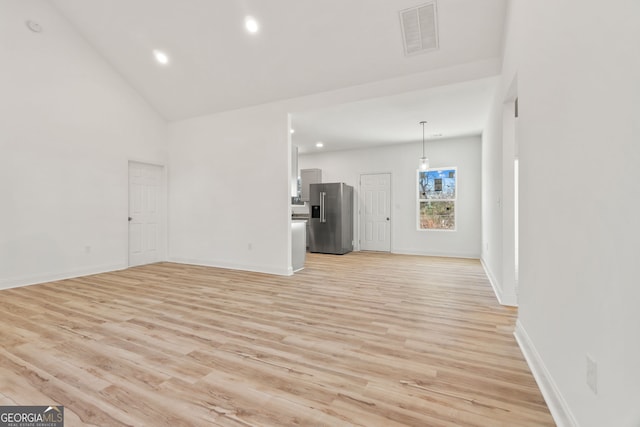 unfurnished living room featuring high vaulted ceiling and light wood-type flooring