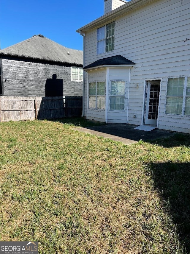 back of property with a lawn