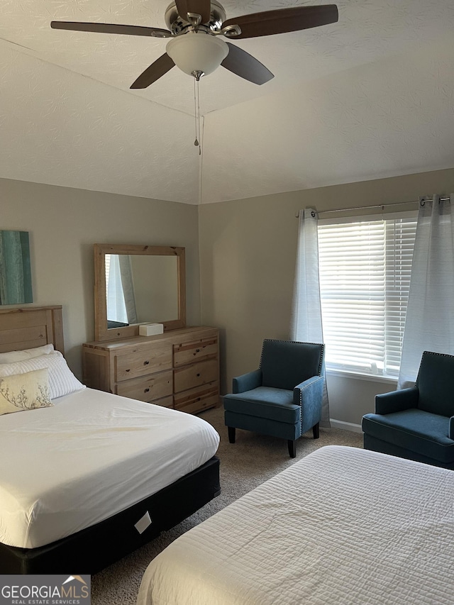 bedroom featuring carpet, ceiling fan, a textured ceiling, and vaulted ceiling