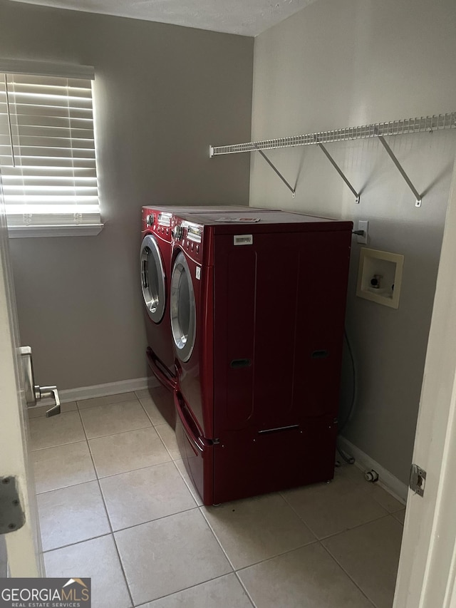 washroom featuring washer and clothes dryer and light tile patterned flooring