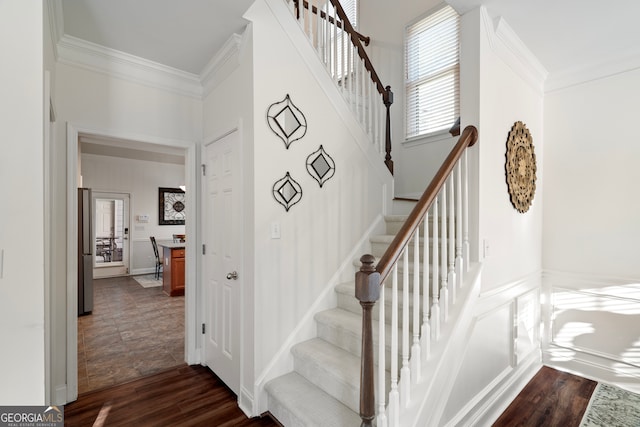 staircase with hardwood / wood-style flooring and ornamental molding