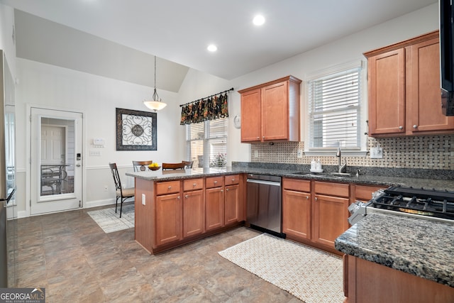 kitchen featuring lofted ceiling, backsplash, hanging light fixtures, appliances with stainless steel finishes, and kitchen peninsula