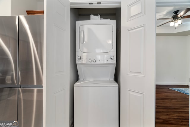 laundry area featuring stacked washer and dryer, ceiling fan, and dark wood-type flooring