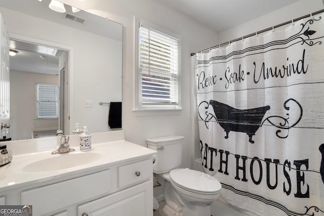 bathroom featuring walk in shower, vanity, and toilet