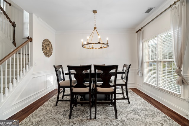 dining area featuring a wealth of natural light, ornamental molding, wood-type flooring, and an inviting chandelier