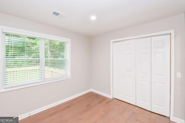 unfurnished bedroom featuring light hardwood / wood-style flooring and a closet