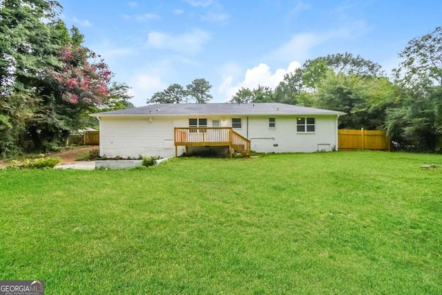 back of property with a lawn and a wooden deck