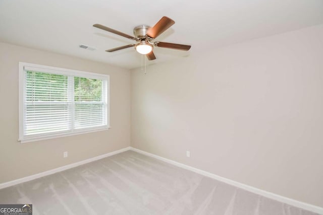 carpeted spare room with ceiling fan