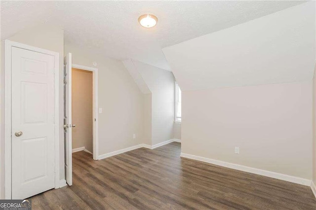 bonus room with vaulted ceiling, a textured ceiling, and dark hardwood / wood-style floors