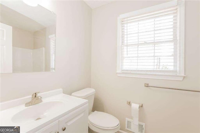 bathroom featuring vanity, a healthy amount of sunlight, and toilet