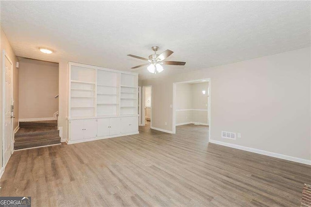 unfurnished bedroom with ceiling fan, light hardwood / wood-style flooring, a textured ceiling, and a closet