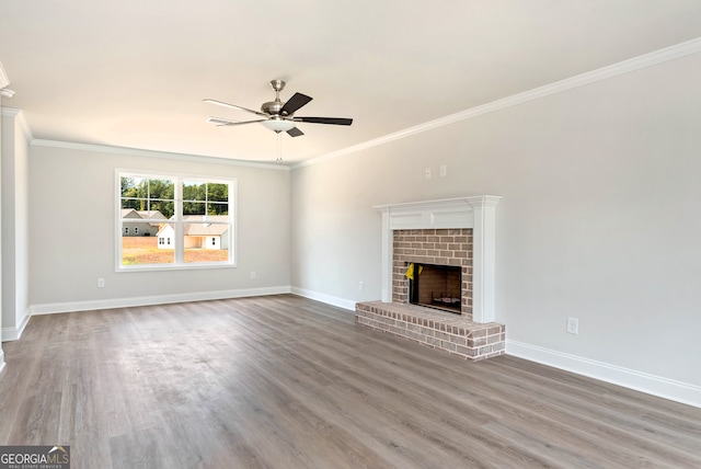 unfurnished living room with a fireplace, hardwood / wood-style flooring, ceiling fan, and crown molding