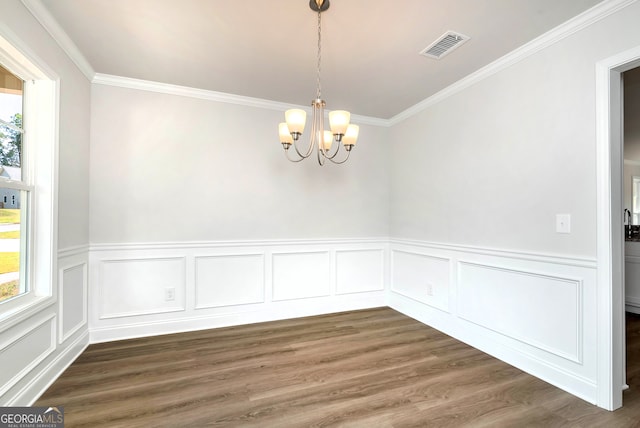 unfurnished dining area with dark hardwood / wood-style flooring, a notable chandelier, and ornamental molding