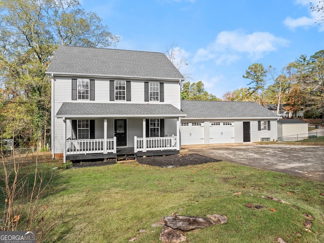 view of front of property featuring a front yard, a garage, and covered porch