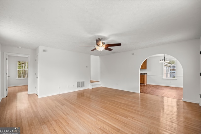 spare room with ceiling fan, light hardwood / wood-style floors, and a textured ceiling