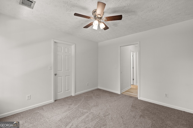 carpeted spare room with a textured ceiling and ceiling fan