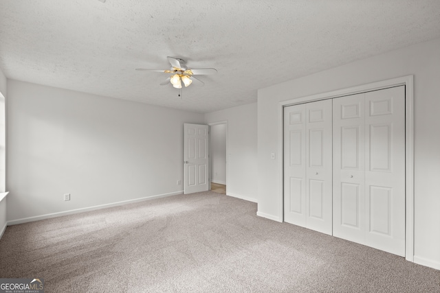 unfurnished bedroom with ceiling fan, a closet, carpet floors, and a textured ceiling