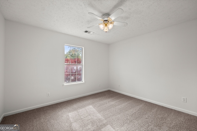 spare room with a textured ceiling, carpet floors, and ceiling fan