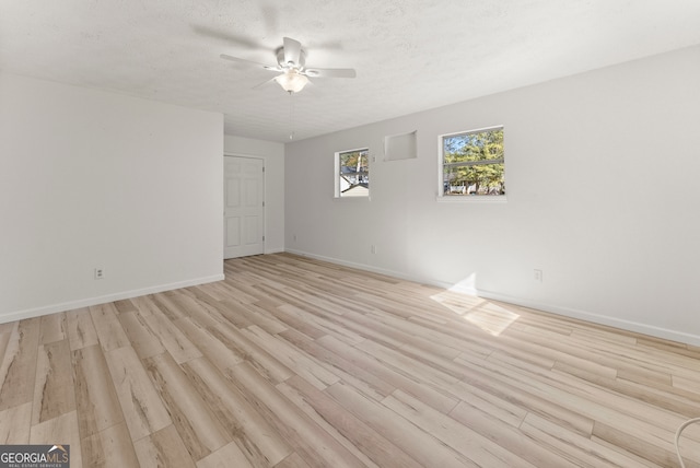 empty room featuring a textured ceiling, light hardwood / wood-style floors, and ceiling fan