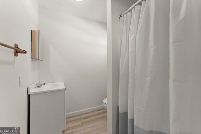 bathroom with vanity, wood-type flooring, and toilet