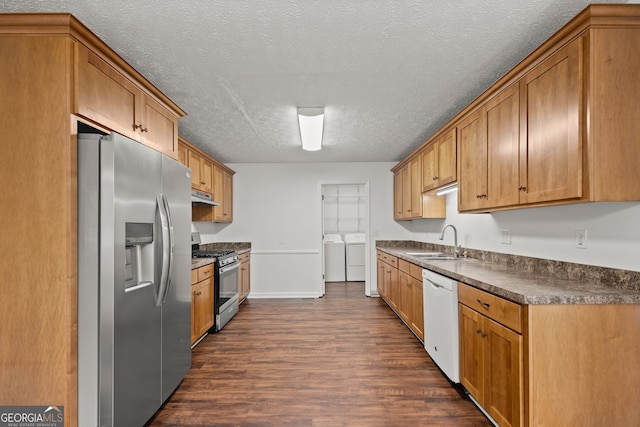 kitchen featuring washer and dryer, stainless steel appliances, dark wood-type flooring, and sink