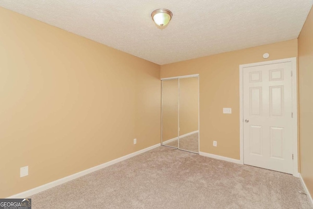 unfurnished bedroom with light carpet and a textured ceiling