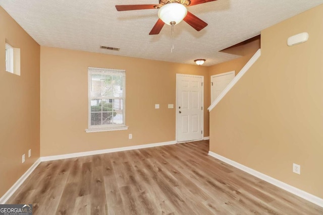 foyer entrance with a textured ceiling, light hardwood / wood-style floors, and ceiling fan