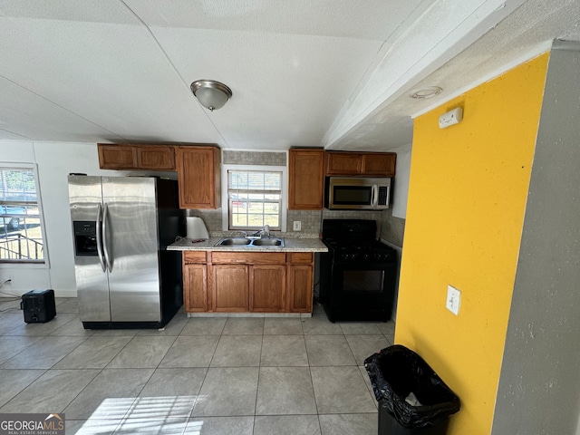 kitchen featuring sink, stainless steel appliances, backsplash, a textured ceiling, and light tile patterned floors