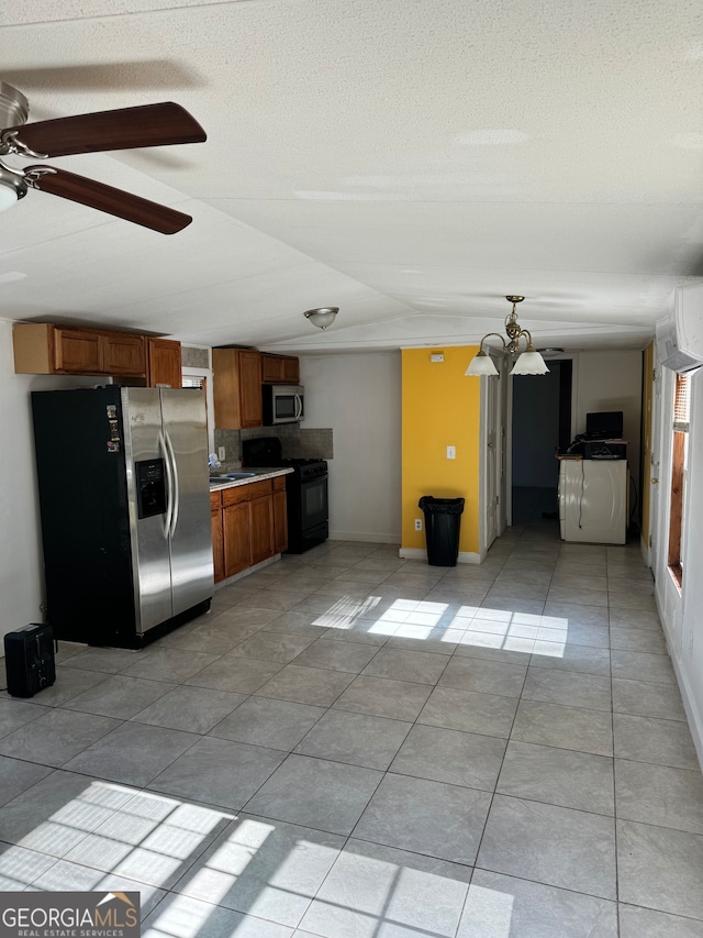 kitchen with a notable chandelier, light tile patterned flooring, sink, and appliances with stainless steel finishes