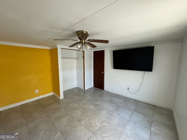 unfurnished bedroom featuring ceiling fan, ornamental molding, a textured ceiling, and a closet