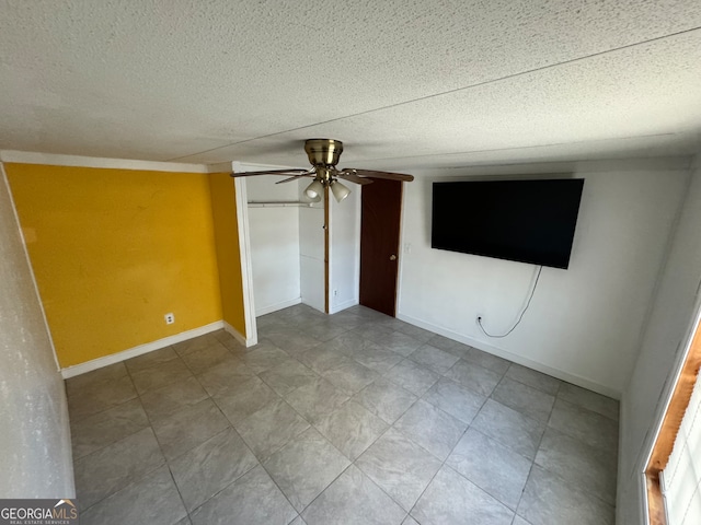 empty room featuring ceiling fan and a textured ceiling