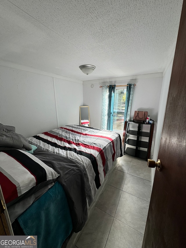 tiled bedroom featuring a textured ceiling