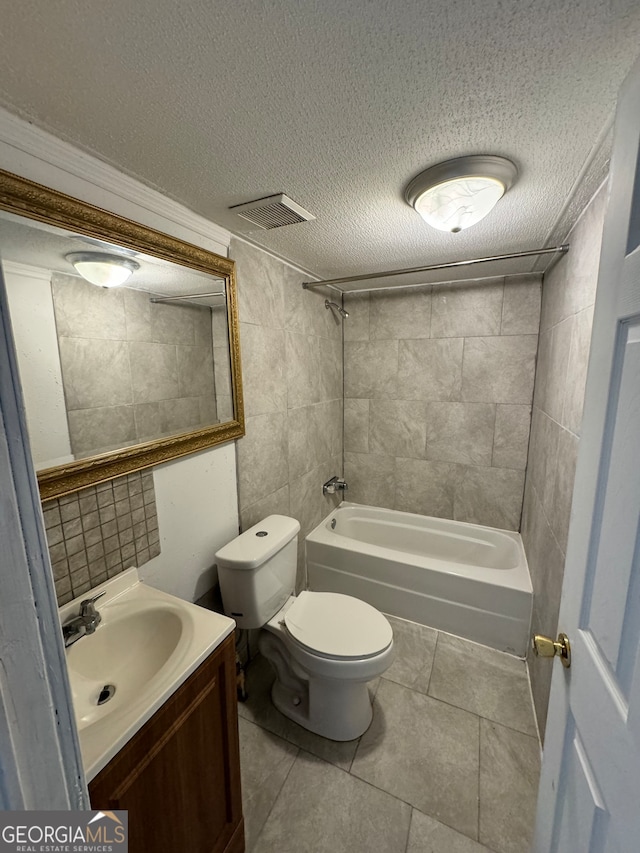 full bathroom with tile patterned floors, vanity, a textured ceiling, and tiled shower / bath