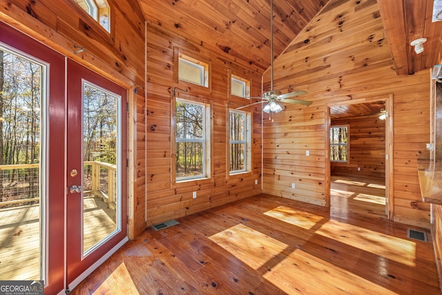 interior space with light wood-type flooring, high vaulted ceiling, wooden walls, and wood ceiling