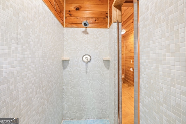 bathroom with wood-type flooring and wood walls