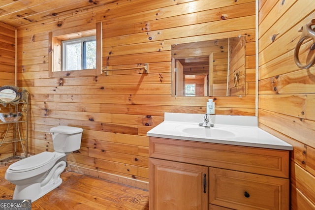 bathroom with hardwood / wood-style floors, toilet, wooden walls, vanity, and wood ceiling