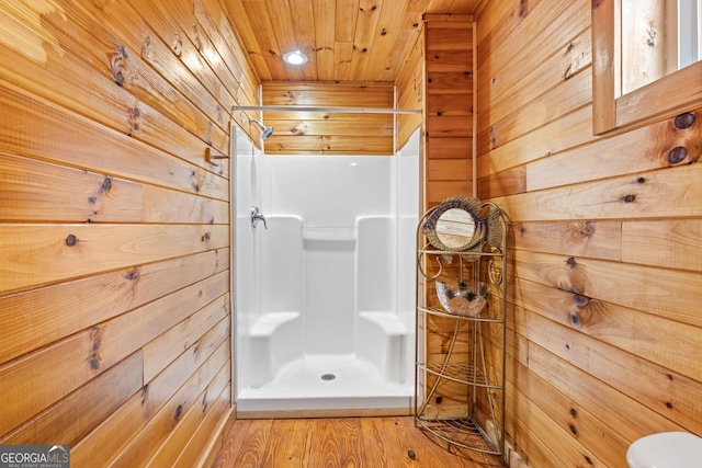 bathroom with hardwood / wood-style floors, wooden ceiling, walk in shower, and wooden walls