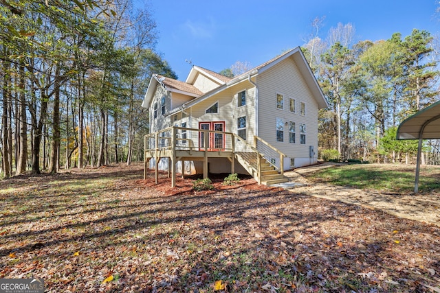 view of side of property featuring a carport and a wooden deck