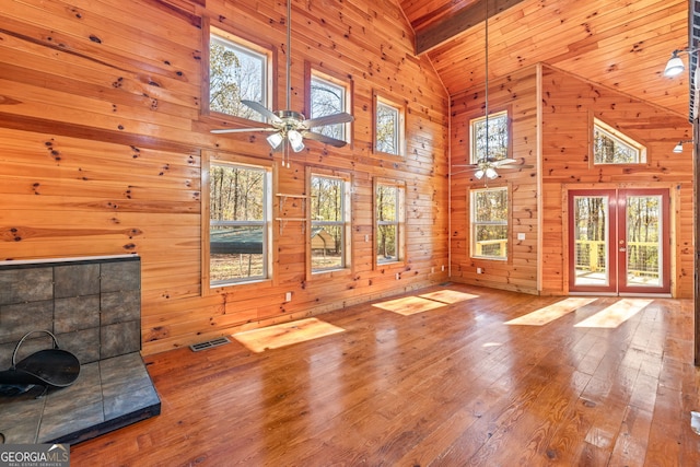 unfurnished living room featuring hardwood / wood-style floors, plenty of natural light, and high vaulted ceiling