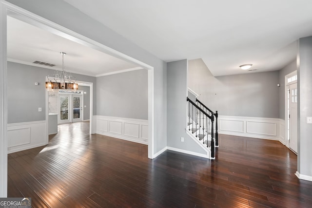 interior space with french doors, a chandelier, crown molding, and dark hardwood / wood-style floors