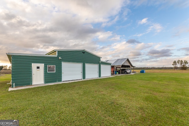 garage featuring a carport and a yard