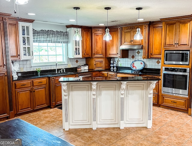 kitchen featuring a center island, backsplash, sink, hanging light fixtures, and stainless steel appliances