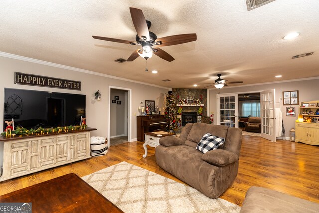 living room with crown molding, a textured ceiling, and hardwood / wood-style flooring