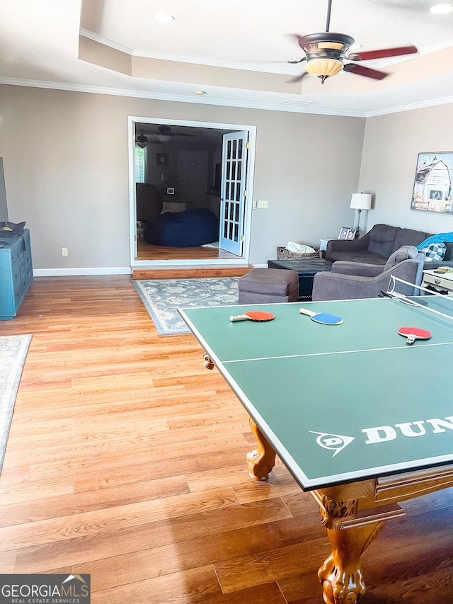 recreation room featuring hardwood / wood-style floors, ceiling fan, and crown molding