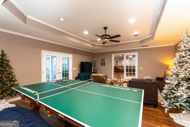 recreation room featuring hardwood / wood-style floors, a tray ceiling, and french doors