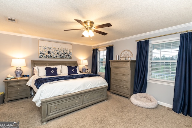 carpeted bedroom with a textured ceiling, multiple windows, ornamental molding, and ceiling fan