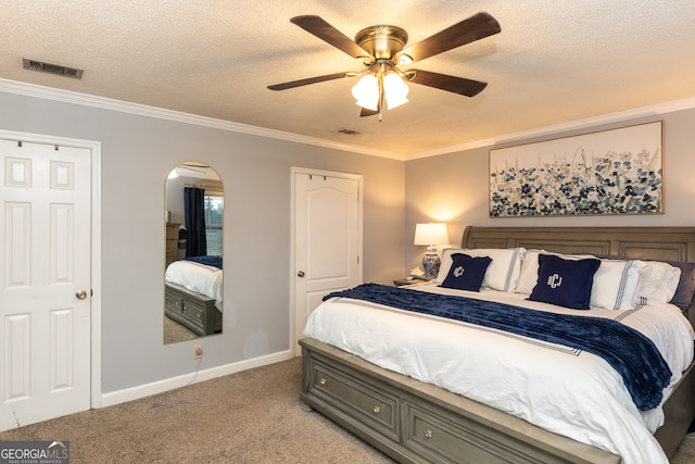 carpeted bedroom featuring ceiling fan, crown molding, and a textured ceiling