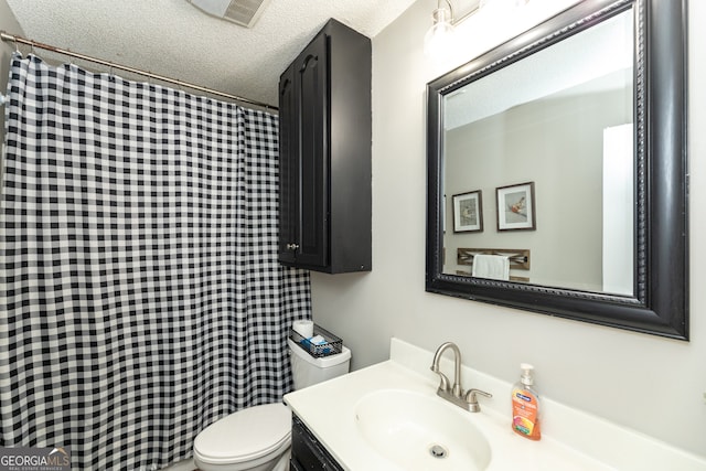 bathroom featuring vanity, toilet, and a textured ceiling