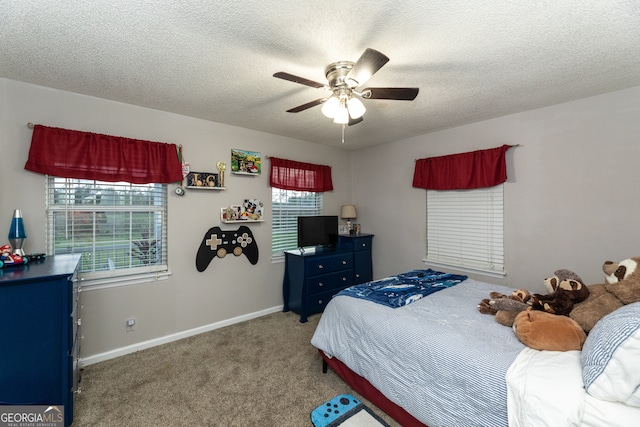 carpeted bedroom with ceiling fan and a textured ceiling