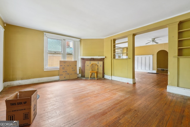 unfurnished living room with wood-type flooring and ceiling fan